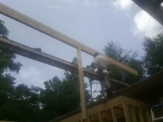 Carpenter setting a ridge beam over a new addition frame — Ice Dam Removal by Roofing Brothers in Bedminster