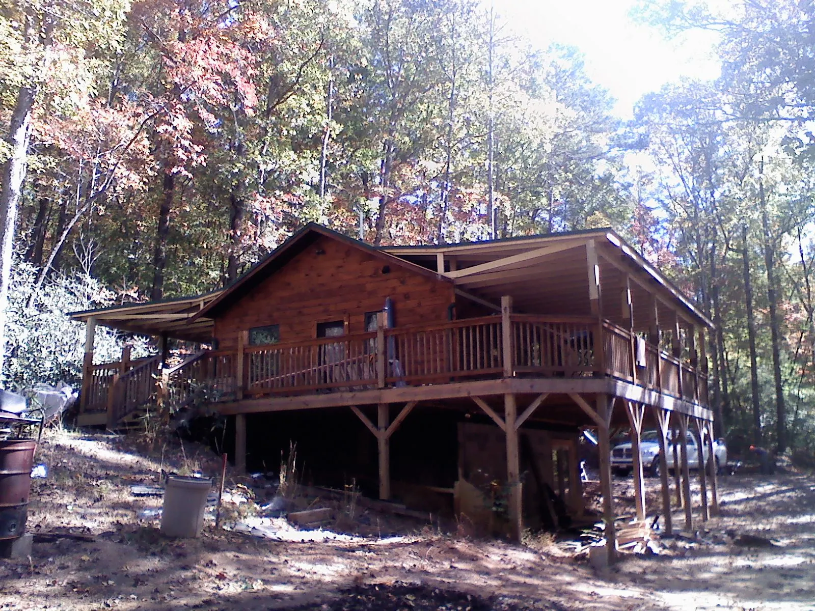 Log cabin with a wraparound porch and metal roof in the fall in Bedminster