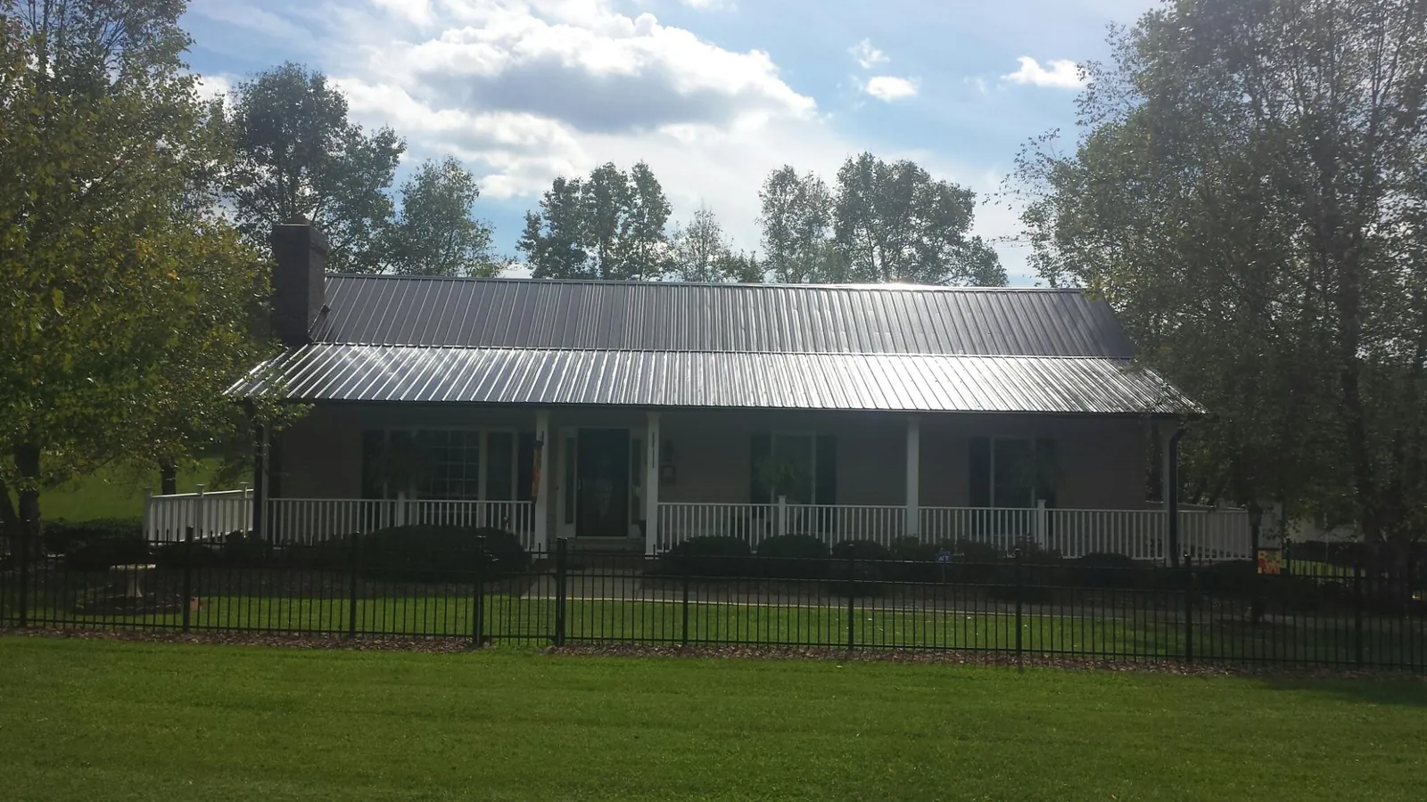 Gray metal roof on a brick ranch with a full width front porch — Gutter Guard Installation work by our crew in Bedminster