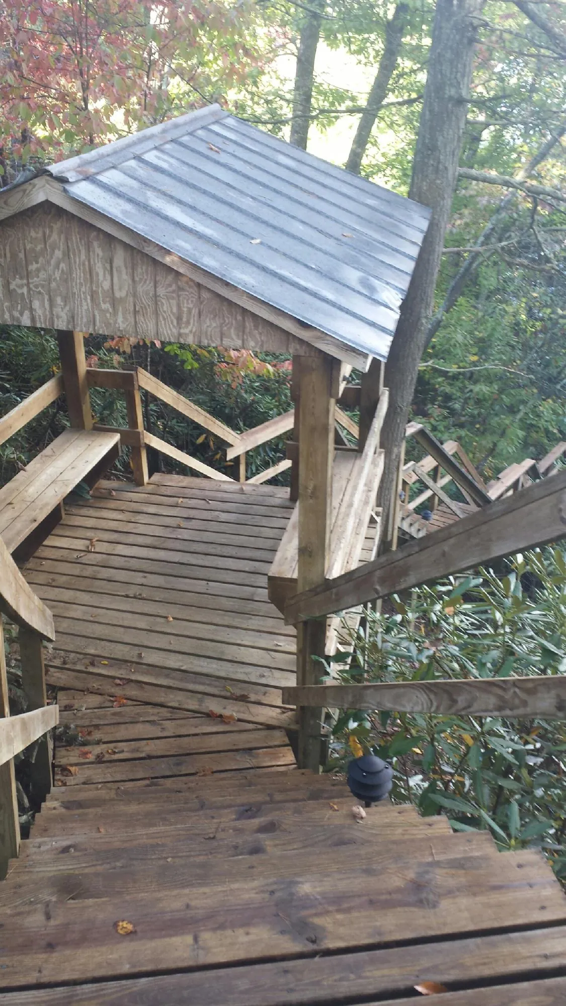 Metal roofed shelter over wooden steps on a wooded walkway — Skylight Repair & Installation work by our crew in Bedminster